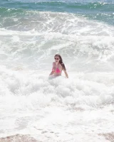 Sweet brunette Natalie Moore is sexy in the sea and on the beach wearing blue and pink bikini