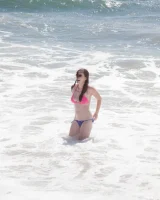Sweet brunette Natalie Moore is sexy in the sea and on the beach wearing blue and pink bikini
