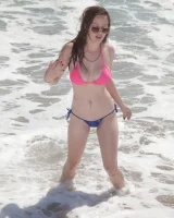 Sweet brunette Natalie Moore is sexy in the sea and on the beach wearing blue and pink bikini