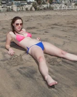 Sweet brunette Natalie Moore is sexy in the sea and on the beach wearing blue and pink bikini