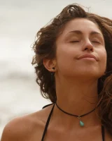 Brunette American Sonya Ash strips her bikini top on the beach and poses