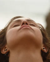 Brunette American Sonya Ash strips her bikini top on the beach and poses