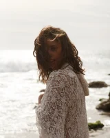 Brunette American Sonya Ash strips her bikini top on the beach and poses