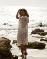 Brunette American Sonya Ash strips her bikini top on the beach and poses