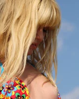 Blonde in motley bikini goes nude on the rocks