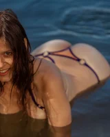 Perfect body young brunette in sexy micro bikini swimming nude