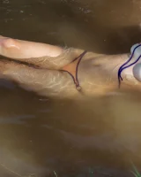 Perfect body young brunette in sexy micro bikini swimming nude