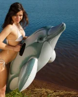 Playing on toy dolphin in sexy white bikini and nude in the lake