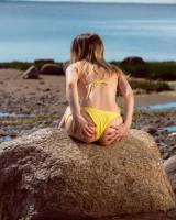 Stripping yellow bikini at the sea