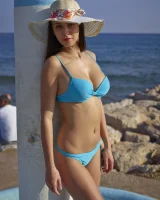 Busty beauty in blue bikini beachside