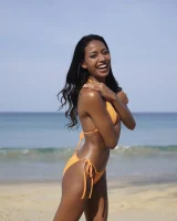 Latin baby in orange bikini with cameltoe undressed on the beach