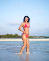 Puffy nipples passionate brunette in red bikini strips in the lake water