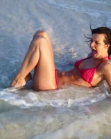 Puffy nipples passionate brunette in red bikini strips in the lake water