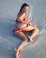 Puffy nipples passionate brunette in red bikini strips in the lake water