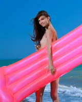 Young playful puffy nipples brunette baby in blue bikini goes nude on the beach on toy float