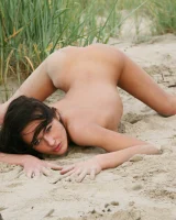 Brunette chick in red bikini goes nude on the beach