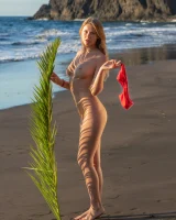 Blonde beach fairy in red bikini with green palm leaf strips her puffy nipples sexy body