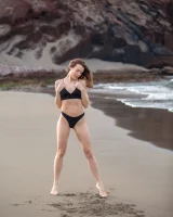 Perfect body girl in black bikini is nude on the beach with erected nipples