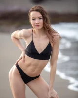 Perfect body girl in black bikini is nude on the beach with erected nipples