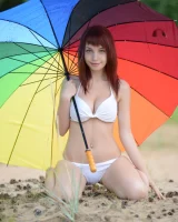 Exciting busty redhead in white bikini is nude on the beach