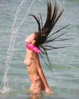 Slim body sexy brunette in white bikini is naked in the sea