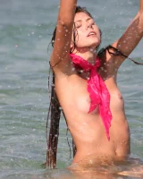 Slim body sexy brunette in white bikini is naked in the sea