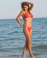 Hot busty girl in red bikini going nude at the seaside