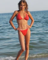 Hot busty girl in red bikini going nude at the seaside