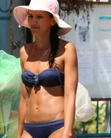 Candid girl on the beach and walking nearby in sexy bikinis