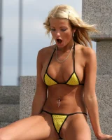 A girl in tight skirt showing a yellow string bikini with cameltoe outside