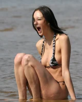 Exciting young flexible brunette in bikini outside in the water