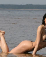 Exciting young flexible brunette in bikini outside in the water