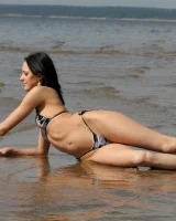 Exciting young flexible brunette in bikini outside in the water