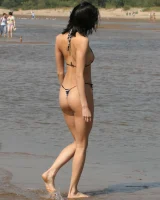 Exciting young flexible brunette in bikini outside in the water