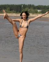 Exciting young flexible brunette in bikini outside in the water