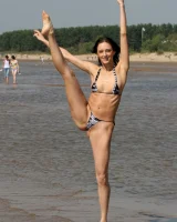 Exciting young flexible brunette in bikini outside in the water