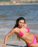 Sexy brunette hottie in pink bikini on the beach