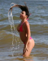Sexy brunette hottie in pink bikini on the beach
