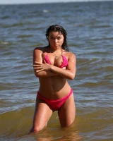 Sexy brunette hottie in pink bikini on the beach