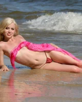Wondeful topless blonde in tiny bikini in the sea, shore and beach