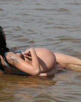 Exciting busty brunette in bikini has fun in the sea flashing her big tits