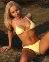 Blonde whore in yellow bikini in the forest showing her sexy body