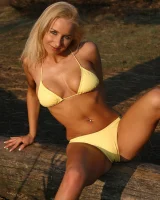 Blonde whore in yellow bikini in the forest showing her sexy body