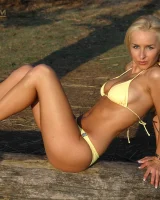Blonde whore in yellow bikini in the forest showing her sexy body