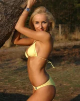 Blonde whore in yellow bikini in the forest showing her sexy body