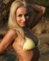 Blonde whore in yellow bikini in the forest showing her sexy body