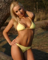 Blonde whore in yellow bikini in the forest showing her sexy body