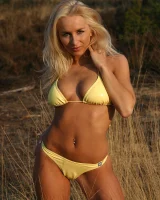 Blonde whore in yellow bikini in the forest showing her sexy body