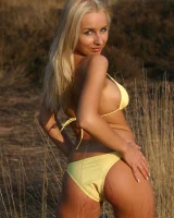 Blonde whore in yellow bikini in the forest showing her sexy body