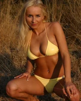 Blonde whore in yellow bikini in the forest showing her sexy body